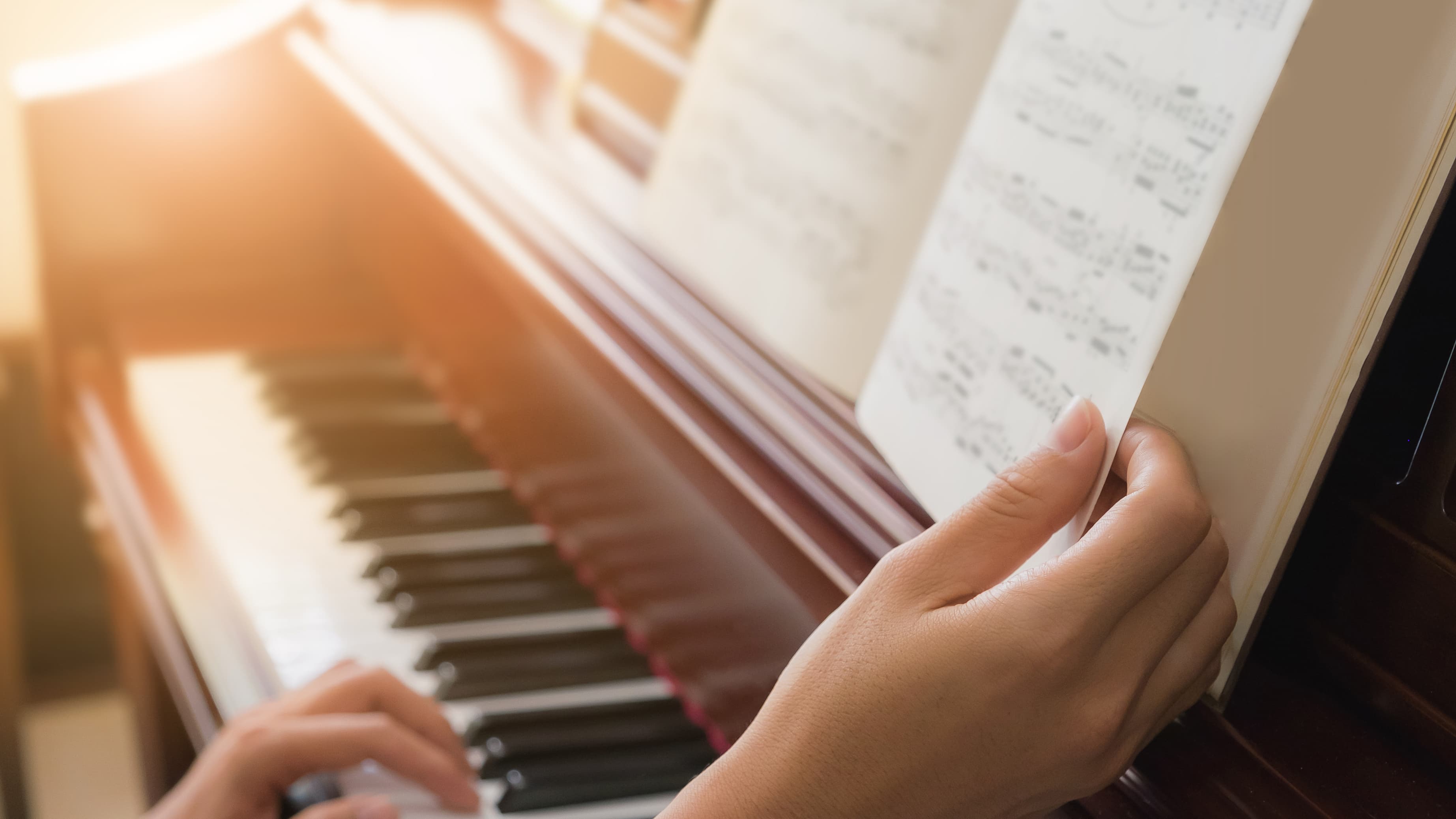 Person reading music on piano